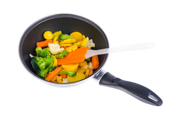 Frying pan with mix of frozen vegetables, isolated on white background.
