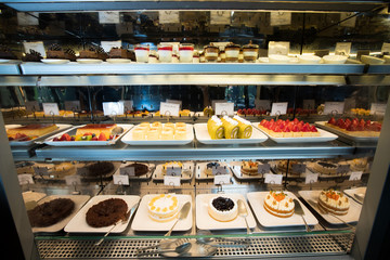 Many Good Looking design and colorful Bakery Cake in refrigerator windows show, present variety of Price and vanilla chocolate birthday cake for special occasion in many style taste and sweet on shelf