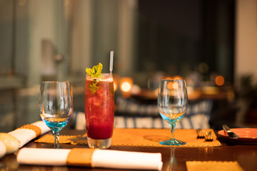 Red Juicy Fruit refreshment in high Glass with straw tube with ice and topping decoration for customer, Fresh smoothies Juice from natural to make diet good health for Dinner table with wine glasses