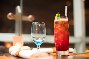 Red Juicy Fruit refreshment in high Glass with straw tube with ice and topping decoration for customer, Fresh smoothies Juice from natural to make diet good health for Dinner table with wine glasses
