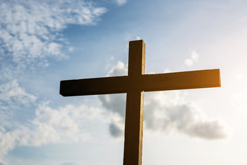 Conceptual wood cross or religion symbol over a sunset sky with clouds background for God. belief or resurrection of god and worship christian. Eucharist Therapy Bless God Helping. Christian Religion