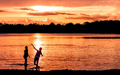 People are having fun in a lake under sunset	