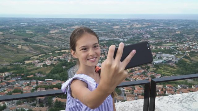 Little girl child makes selfie on background San Marino
