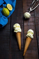 two Ice cream cones lemon flavored on a wooden back ground 