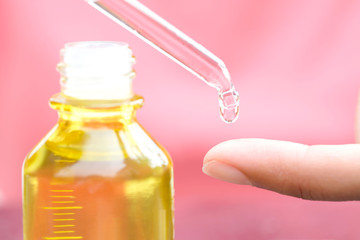 hands of a beautiful woman Dropping serum collagen moisturizer of face into clear yellow bottle soft light background. Protector skin Treatment facial essence oil, Vitamin C. Beauty and spa Con