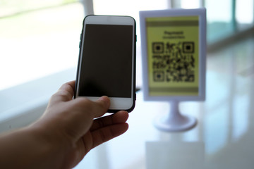 Hands use the phone to scan QR codes to receive discounts on purchases.