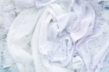 Obraz na płótnie Canvas White shirt soak in powder detergent water dissolution. Laundry concept