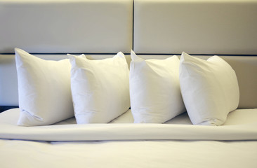 Fototapeta na wymiar Close view of four pillows on a freshly made hotel bed 