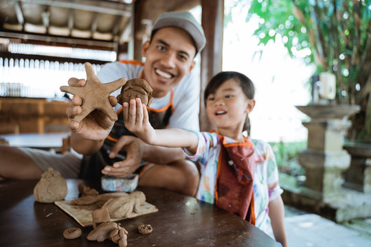 Asian Father And Daughter Making Pottery Together With Clay