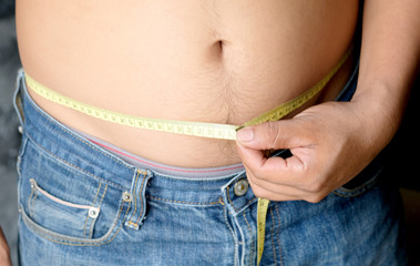Hands of fat man He measured waist circumference with waist circumference.