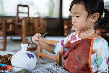 daughter learning about painting color in pottery workshop