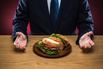サンドイッチを食べるビジネスマン