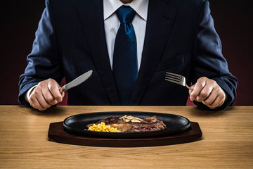 ステーキを食べるビジネスマン