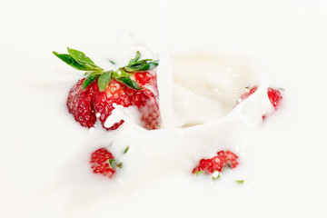 Red natural ripe strawberries falling into milk cream