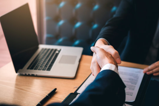 Department heads manager are shaking hands and accept to new employee in office room.