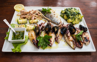 Squids, mussels and octopus with grilled vegetables and sauce.