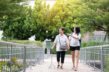 Attempt elderly asian woman walking to do workout with stick at public park,Daughter take care and...