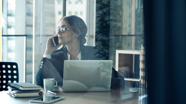 Businesswoman Talking On Cell Phone In Office