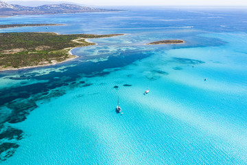 View from above, stunning aerial view of some boats sailing on a beautiful turquoise clear water. Spiaggia La Pelosa (Pelosa beach) Stintino, Sardinia, Italy.