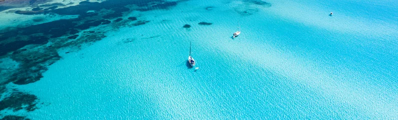 Foto auf Acrylglas Strand La Pelosa, Sardinien, Italien Blick von oben, atemberaubende Luftaufnahme einiger Boote, die auf einem wunderschönen türkisfarbenen klaren Wasser segeln. Spiaggia La Pelosa (Strand von Pelosa) Stintino, Sardinien, Italien.