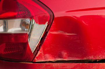 tail light car. broken rear brake light. red passenger car. dent and scratch on the rear fender....