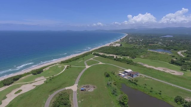 Drone shot of beautiful, lush golf course near a long, white beach in Tela (Northern Honduras), in the Caribbean.