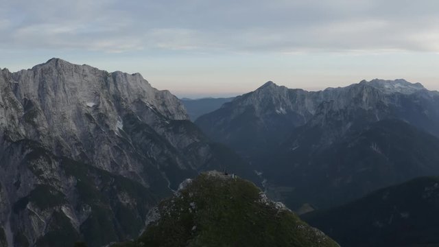 Group Of People With Dog On Top Of The Mountain Straight Line Shot Revealing Valley Between Mountains, Mangart Bovec, Slovenia