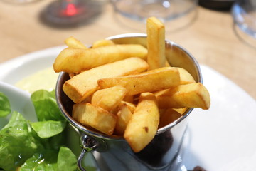 Petit seau de frites traditionnelles dans une assiette blanche