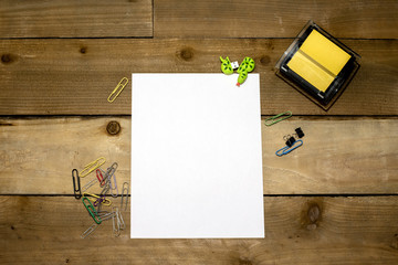 Sticky note dispenser with paperclips, thumb drive and blank vertical 8.5x11 for your copy on distressed wooden background