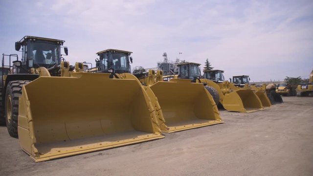 A construction site with rows of bulldozers waiting to be put to work