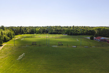 Aerial/Drone view of soccer/football field complex during the afternoon with shadows from clouds on the field in Ontario, Canada.