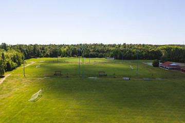 Aerial/Drone view of soccer/football field complex during the afternoon with shadows from clouds on the field in Ontario, Canada.