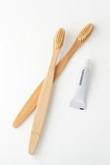 Bamboo toothbrushes and toothpaste on white