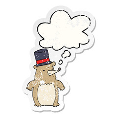 cartoon bear in top hat and thought bubble as a distressed worn sticker