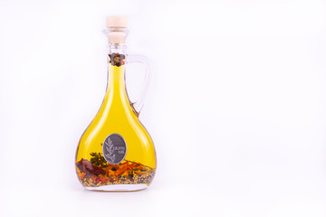 Extra virgin olive oil bottle with herbs and spices on white background