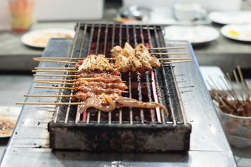 Grilled pork on the stove. Fresh meat grilled on charcoal stove. Charcoal stove made of black steel