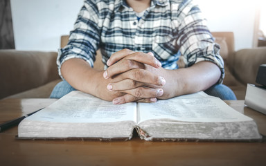 Close up hands of man reading on Bible or book at home. christian concept.