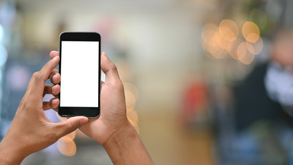 Smartphone on hands with empty screen and bokeh on blur background.