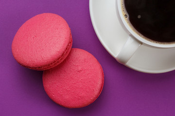 Pink cookies on a purple background. With a cup of coffee.
