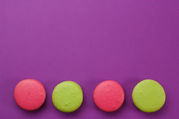 Pink and green cookies on a purple background.