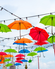 Brightly coloured open umbrellas in Zagreb Croatia with the cathedral spires in the background 