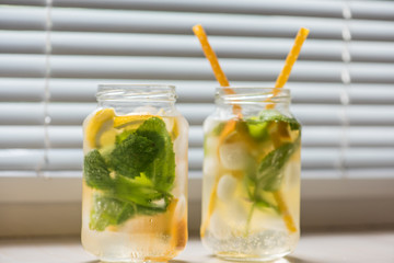 non-alcoholic summer drink with lemon, orange ice, on a light background, high key 
