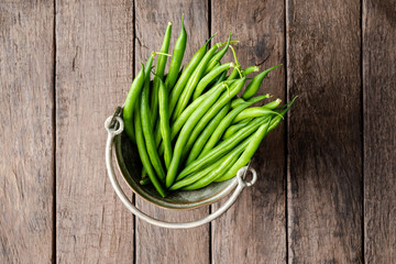 Fresh green bean on old wooden table. Top view
