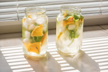 non-alcoholic summer drink with lemon, orange ice, on a light background, high key 
