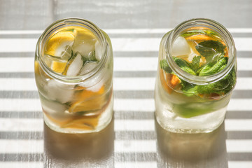 non-alcoholic summer drink with lemon, orange ice, on a light background, high key 
