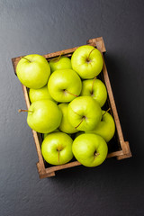 Overhead shot of green apples in wooden box
