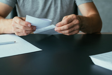 Written communication. Cropped shot of man inserting letter into envelope. Copy space.