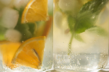 non-alcoholic summer drink with lemon, orange ice, on a light background, high key 