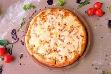 Pizza with bacon and cheese on wooden board on the table. Close-up view