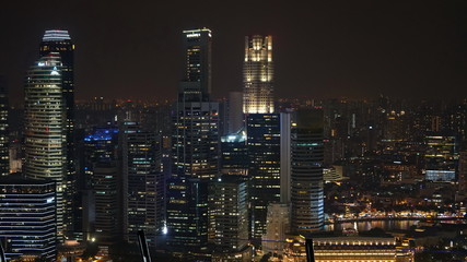 Landscape views of Singapore skyline at night. Buildings with offices and tall skyscraper as foreground.